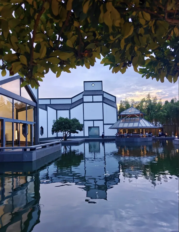 Suzhou Museum's waterside facade at dusk